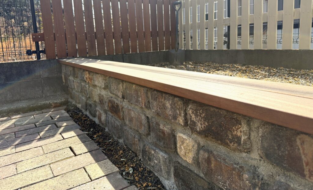 アンティークレンガのレイズドベッドにウリン材ベンチを取り付けた完成状態