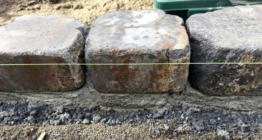 アンティークレンガを水平を確認しながら一段ずつ積み上げている様子