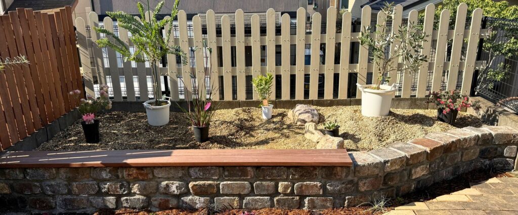 レイズドベッドにアカシアブルーブッシュを含めた植栽配置を仮置きして検討している様子