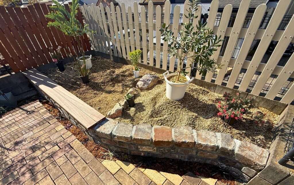 レイズドベッドに植物を並べて配置確認している様子