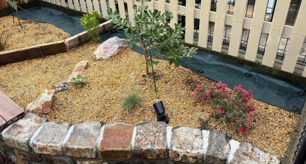 レイズドベッドの防草シート施工（植栽エリア奥の雑草対策）