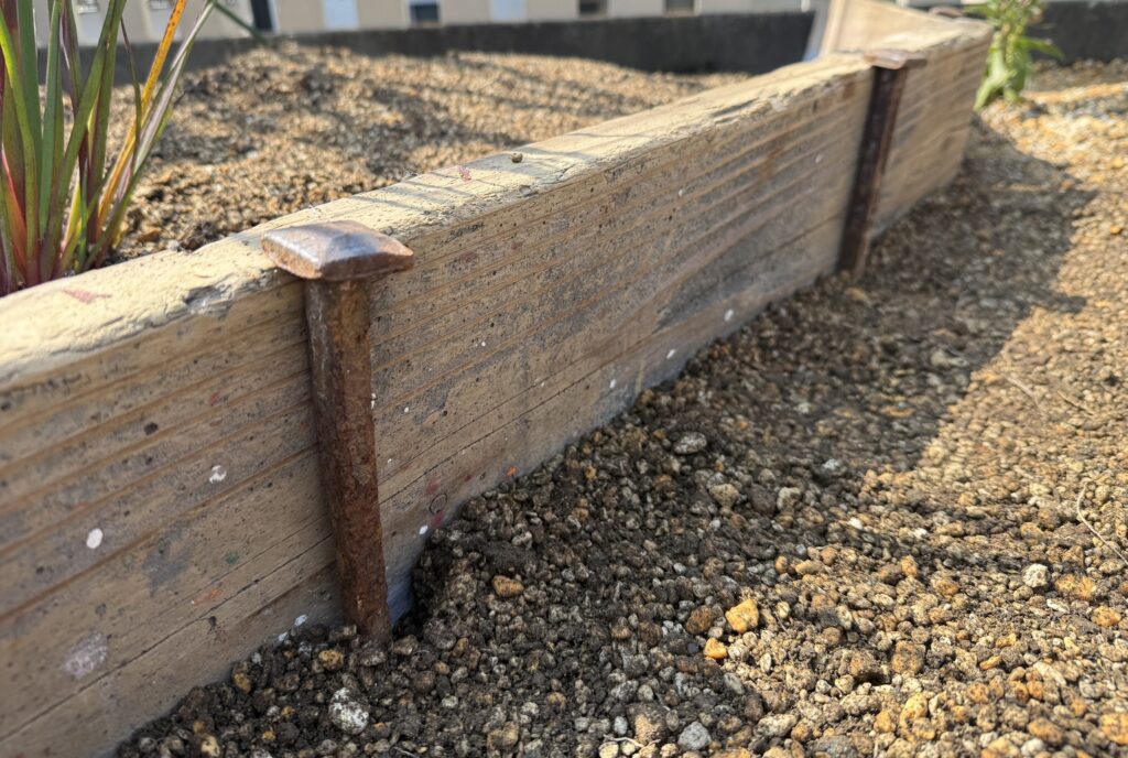 古材を使った土留めの設置後（錆びた杭で固定した状態）